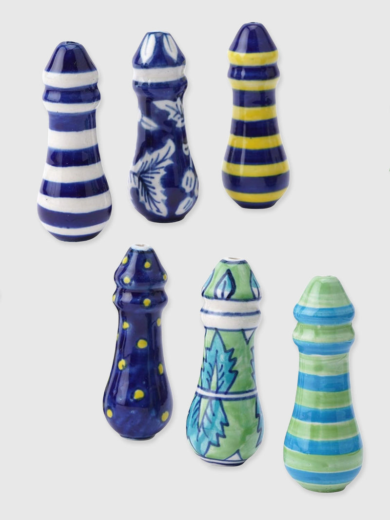 A selection of ceramic bathroom light pulls in various designs and colors, including blue and white stripes and floral patterns.
