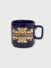 A cobalt blue glazed stoneware mug with real gold plating, featuring the word 'STRYCHNINE' in an ornate, Victorian-style font, accompanied by a gold handle.